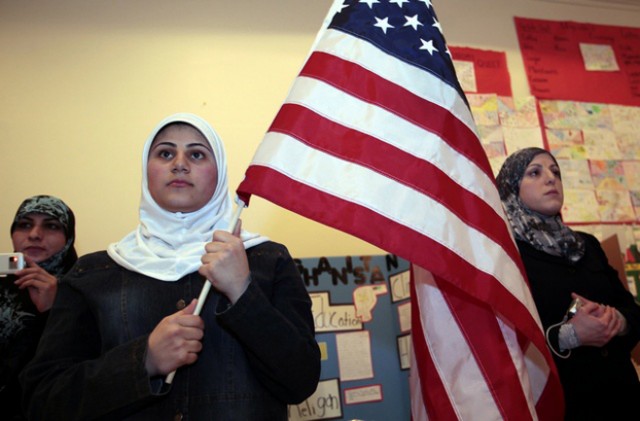 A young Muslim American female student holds the U.S. flag during a 'Children of the World' student pageant at the Islamic Center of America in Dearborn, Michigan, March 26, 2010. A growing school of thought among counterterrorism specialists, and within the administration of U.S. President Barack Obama, argues that law enforcement should engage more deeply with the Muslim community. Their case has been bolstered by encouraging examples of outreach programs. Picture taken March 26. To match SPECIAL REPORT USA-SECURITY/HOMEGROWN REUTERS/Rebecca Cook (UNITED STATES - Tags: RELIGION POLITICS)