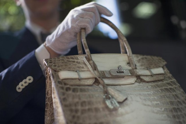 An employee holds an Hermes diamond and Himalayan Nilo Crocodile Birkin handbag at Heritage Auctions offices in Beverly Hills, California September 22, 2014. The handbag has 242 diamonds with a total of 9.84 carats. REUTERS/Mario Anzuoni (UNITED STATES - Tags: ENTERTAINMENT SOCIETY FASHION)