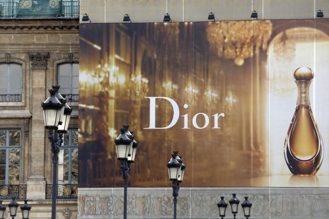 A huge advertisement for Dior perfume installed on the facade of a building is seen at the Place Vendome in Paris March 18, 2014. French luxury group LVMH is trying to push out smaller rivals from plush Place Vendome in Paris after buying one of its highest-profile buildings, illustrating the intensifying battle for Europe's prime retail locations. Cash-rich groups such as LVMH, Richemont and Hermes have been stepping up property investment in key fashion capitals, buying entire buildings to lock in premium sites for which prices and rents are rising fast. Picture taken March 18, 2014. REUTERS/Charles Platiau (FRANCE - Tags: BUSINESS)