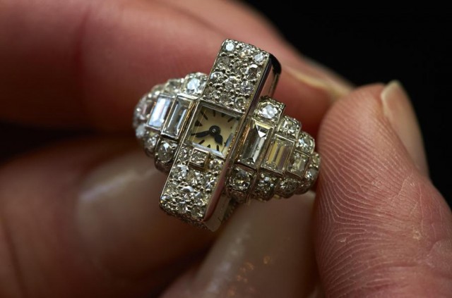 A staff member holds an Art Deco platinum ring watch set with diamonds during an auction preview at Sotheby's in Geneva May 7, 2014. This item made by Cartier around 1937 is equipped with Le Coultre's calibre 101 movement and it is expected to reach between CHF 30,000 and 50,000 (USD 34,100 to 57,000) when it goes on sale May 14, 2014 in Geneva. REUTERS/Denis Balibouse (SWITZERLAND - Tags: SOCIETY WEALTH)