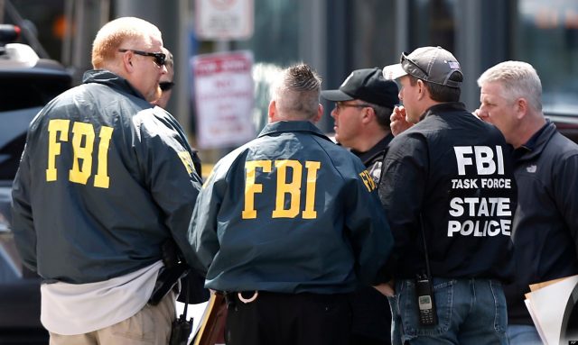 FBI agents gather near the finish line of the Boston Marathon in Boston Tuesday, April 16, 2013. The bombs that ripped through the crowd at the Boston Marathon, killing at least three people and wounding more than 170, were fashioned out of pressure cookers and packed with shards of metal, nails and ball bearings to inflict maximum carnage, a person briefed on the investigation said Tuesday. (AP Photo/Winslow Townson)