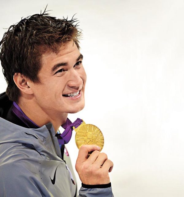US gold medalist Nathan Adrian poses on the podium after the men's 100m freestyle final swimming event at the London 2012 Olympic Games on August 1, 2012 in London. AFP PHOTO / LEON NEAL