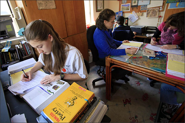 In this March 29, 2011 photo in Durham, N.C., home-schooler Rebecca Lobach, left, studies while mom Mary Lee teaches her siblings. A proposal in the General Assembly would require local public schools to allow home-schoolers to play sports as if they were enrolled there. (AP Photo/Gerry Broome)