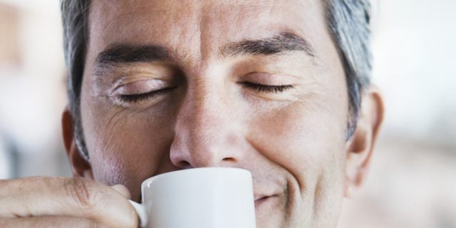Businessman smelling espresso coffee